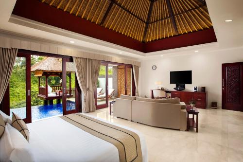 a bedroom with a bed and a living room at Viceroy Bali in Ubud