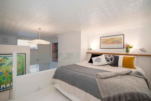 a bedroom with a large bed in a white room at Beachside luxury loft apartment in Melbourne