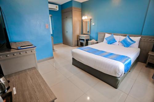 Schlafzimmer mit einem Bett mit blauen Wänden und einem TV in der Unterkunft Eurana Boutique Hotel in Chiang Mai