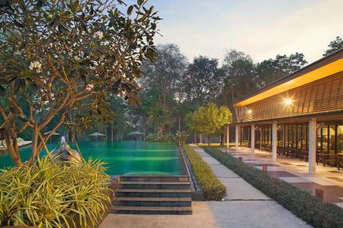 un complexe avec une piscine et un bâtiment dans l'établissement Mida Resort Kanchanaburi - SHA PLUS, à Sai Yok