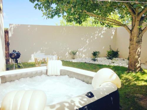 a backyard with a hot tub in the grass at Estrella avec jardinet et Spa en option in Les Sables-dʼOlonne