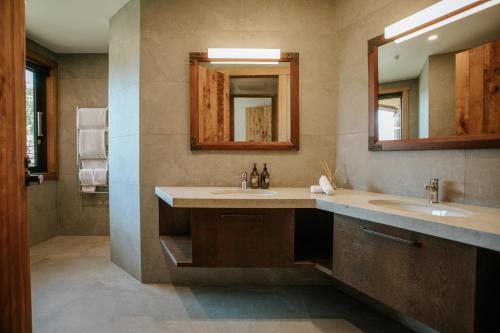 uma casa de banho com 2 lavatórios e um espelho em Stoneridge Estate em Queenstown