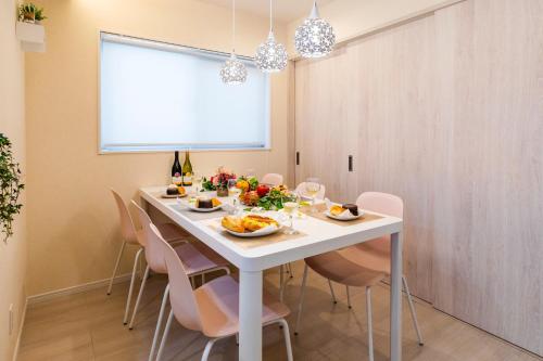 a dining room with a white table and chairs at Condominium Luana 築浅2LDK 宮城海岸徒歩2分 American Village 車で10分 in Chatan