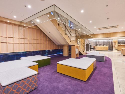 een kamer met 2 bedden en een trap bij Hotel Binario Umeda in Osaka