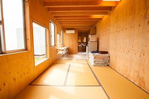 a hallway of a house with yellow flooring and windows at Sunset Breeze Hota in Kyonan