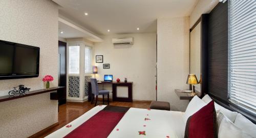 a hotel room with a bed and a desk at Hanoian Central Hotel & Spa in Hanoi