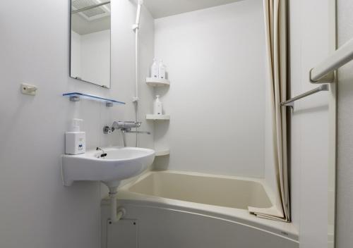倶知安町にあるMidtown Nisekoの洗面台とシャワー付きの白いバスルーム