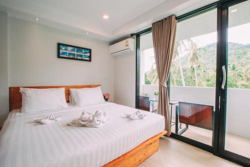 una camera da letto con un letto e asciugamani bianchi di Good Dream Hotel (Khun Ying House) a Ko Tao