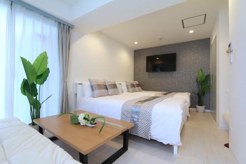 a hotel room with two beds and a tv at NM21 Liz Osaka Castle in Osaka