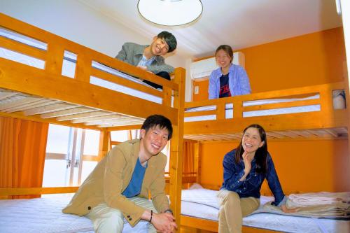 高知的住宿－ゲストハウス ルルル 最大12名可 合宿 大家族 団体旅行にオススメ，一组坐在双层床上的人