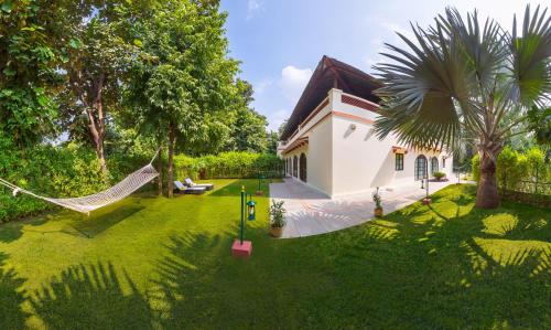 a house with a hammock in a yard at Sawai Madhopur Lodge - IHCL SeleQtions in Sawāi Mādhopur