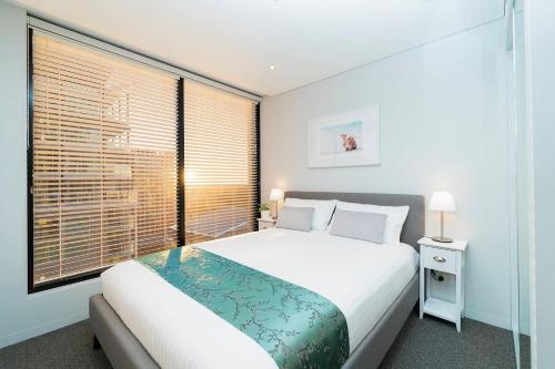 a bedroom with a bed and a large window at Horizons 1402 in Adelaide