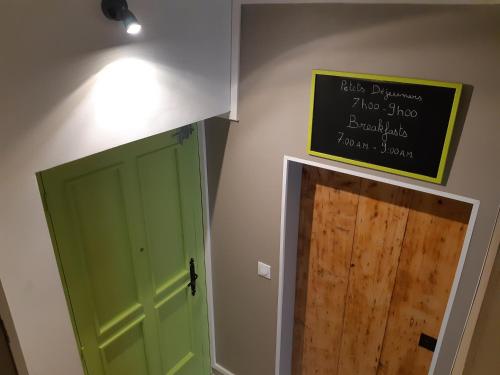 a green door and a sign on a wall at Suite Privée Bed and Breakfast in Nîmes