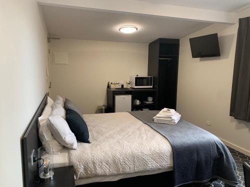 a bedroom with a bed and a microwave in it at Queens Arms Hotel in Longford