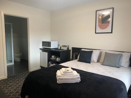 a bedroom with a bed with towels on it at Queens Arms Hotel in Longford