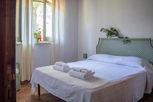 una camera da letto con un letto e due asciugamani di Tenuta San Calogero Appartamento Salvia ad Agnone Bagni