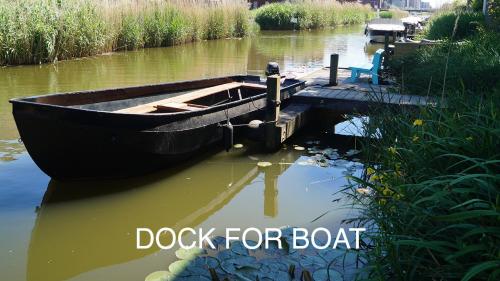a boat parked next to a dock in the water at Room With A Few in Amsterdam
