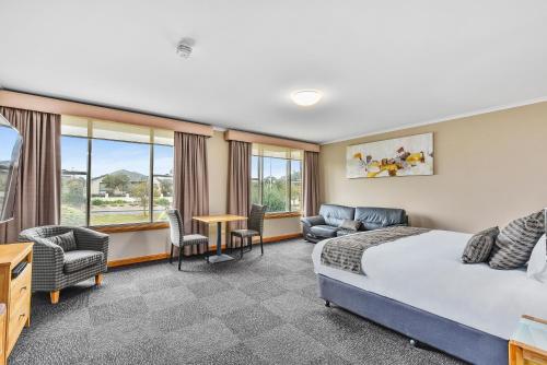 a hotel room with a bed and a table and chairs at Southgate Motel in Mount Gambier