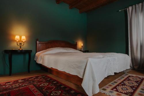 a bedroom with a bed and a green wall at Wooden Barn in Zăbala