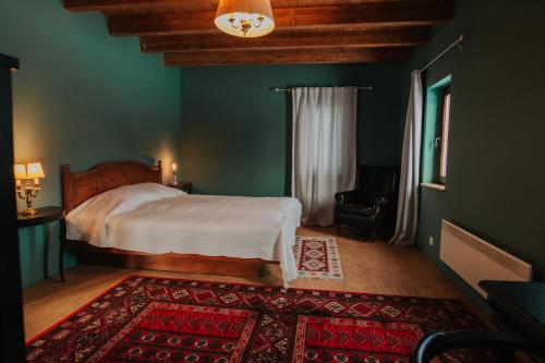 a bedroom with a bed and a green wall at Wooden Barn in Zăbala