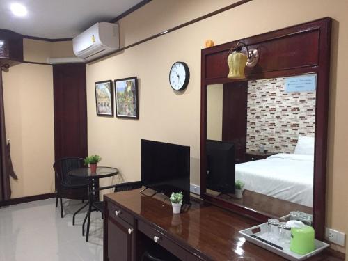 a hotel room with a bed and a desk with a mirror at โรงแรมเมืองเพรียวอินน์ Mueang Phriao Inn Hotel in Sara Buri