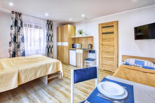ブワディスワボボにあるPokoje u Irenyのベッド2台とキッチンが備わるホテルルームです。