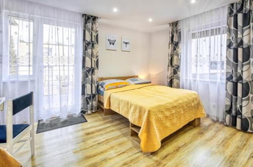 ブワディスワボボにあるPokoje u Irenyのベッドルーム1室(黄色い毛布付きのベッド1台付)