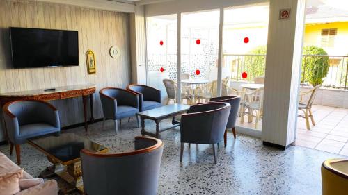 a restaurant with a table and chairs and a television at Hotel Villa Barbara in Can Picafort