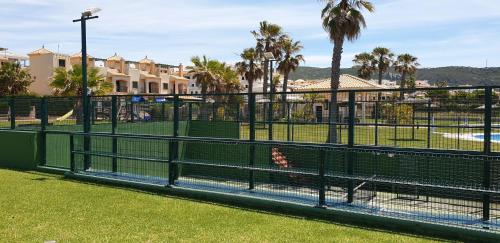 a bird sitting in a cage at a park at ATICOS Primera Linea en ZAHARA DE LOS ATUNES in Zahara de los Atunes