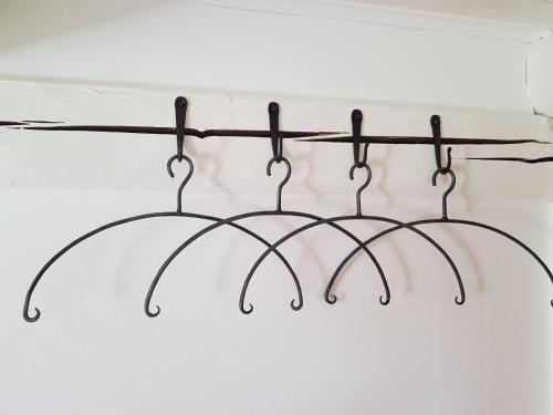 a metal rack with three hangers on a wall at 4B Österlen Bed & Breakfast in Tomelilla