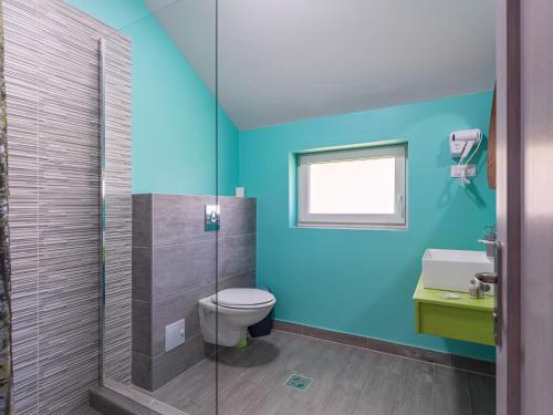 a bathroom with a toilet and a glass shower at HAPPY TIMES in Bran