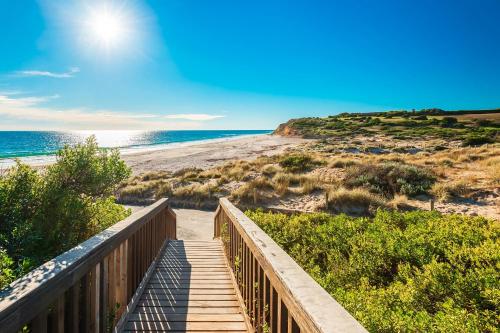 a wooden staircase leading to a beach with the ocean at Horizons 1402 - Free carpark in Adelaide