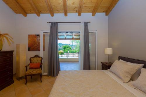 a bedroom with a bed and a chair and a window at Villa Caramel in Agios Ioannis