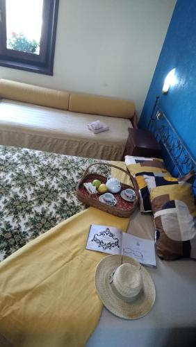 two beds in a room with a hat on the bed at B&B Home Holiday Villa delle Acacie agriturismo in Sala Consilina