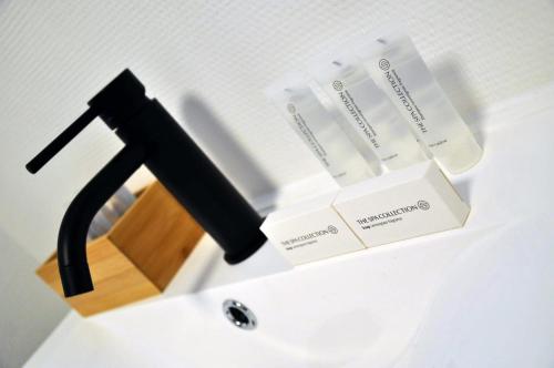 a white sink with a black stand with boxes on it at Spelver95 in Bilzen