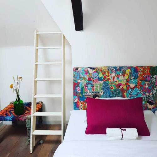 a white bed with a red pillow in a room at Pink Flamingo Boutique Hostel in The Hague