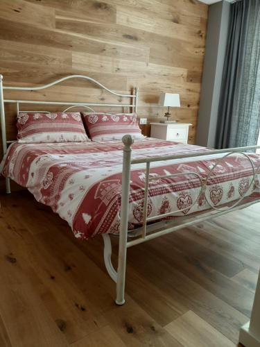 ポンテ・ディ・レーニョにあるSuite Chaletの木製の壁のベッドルーム1室(ベッド1台付)