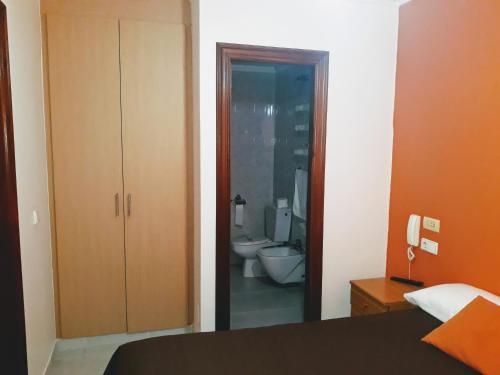 フェロルにあるPorta Nova Apartamentosのベッドルーム1室(トイレ、洗面台付)