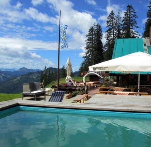 a swimming pool with a view of the mountains at Obere Maxlraineralm in Spitzingsee
