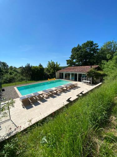 uma piscina com espreguiçadeiras e uma casa em Domaine de La Michelle em Madaillan