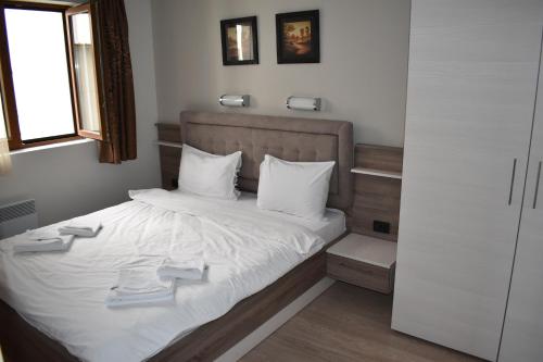 a bedroom with a bed with two towels on it at Apartman G1 u Milmari kompleksu - Kopaonik in Kopaonik
