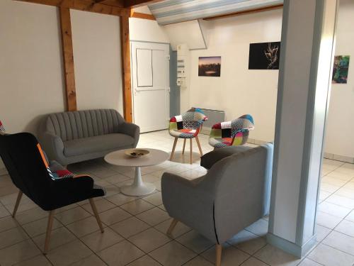 un salon avec un canapé, des chaises et une table dans l'établissement L’Ecrin champenois : 150m2 au cœur du vignoble, à Étoges