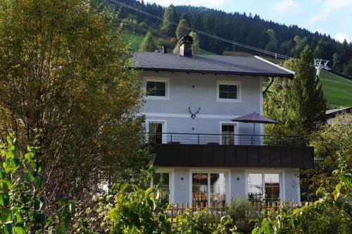 a white house with a balcony on top of it at MyApart Jochberg in Jochberg