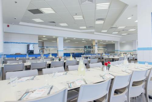 a conference room with white tables and white chairs at HI - Ein Gedi Hostel in Ein Gedi