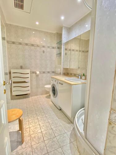 une salle de bain avec un lavabo et une machine à laver dans l'établissement La piètonne, à Menton