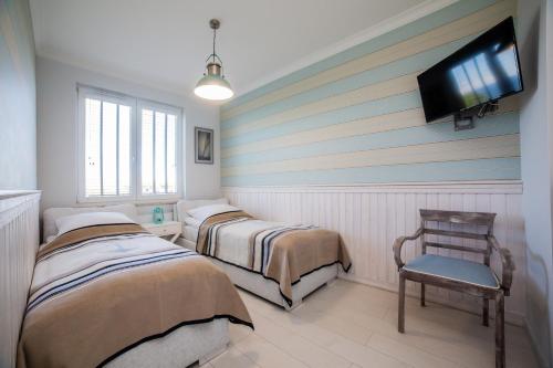 a room with two beds and a tv on the wall at Apart Harmony - Apartament Hampton in Puck