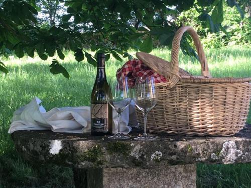 a basket and a bottle of wine and two glasses at Château de Labro - Teritoria in Onet le Château