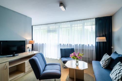 シュツァブニツァにあるHotel Nawigator Szczawnicaのリビングルーム(青いソファ、テレビ付)
