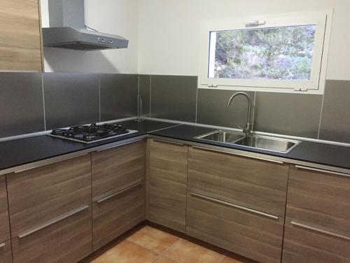 a kitchen with a sink and a stove and a window at CASA ANA in Sant Josep de Sa Talaia
