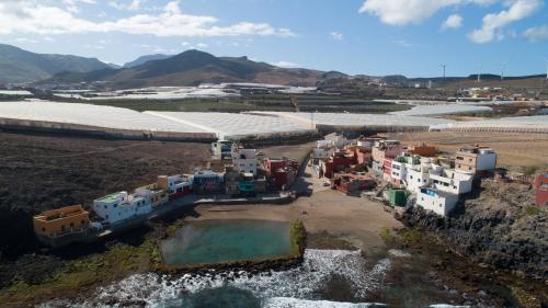 an aerial view of a town in a field with mountains at Casa Playa Ondina in Gáldar